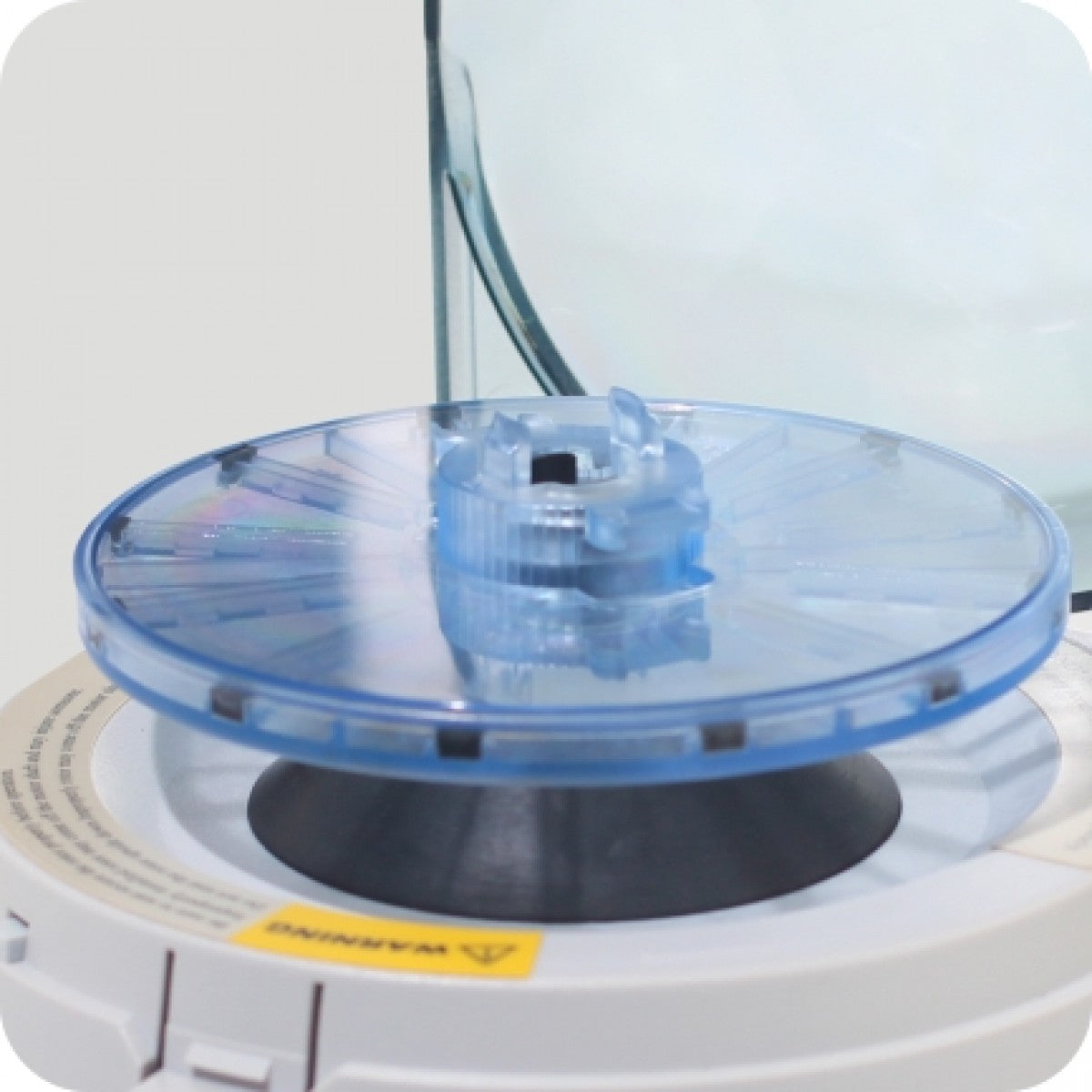 A compact and portable Meteor Handheld Centrifuge black and blue rotor and white body with some black components.