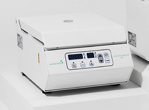 A white NeoGenesis Neo centrifuge with a digital control panel on the front. The device is compact and has a modern look, with buttons and a screen for operational control.