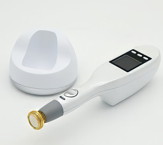 A handheld non-invasive plasma treatment device with a gold tip component lying on a surface. It is a great plasma device purchase.