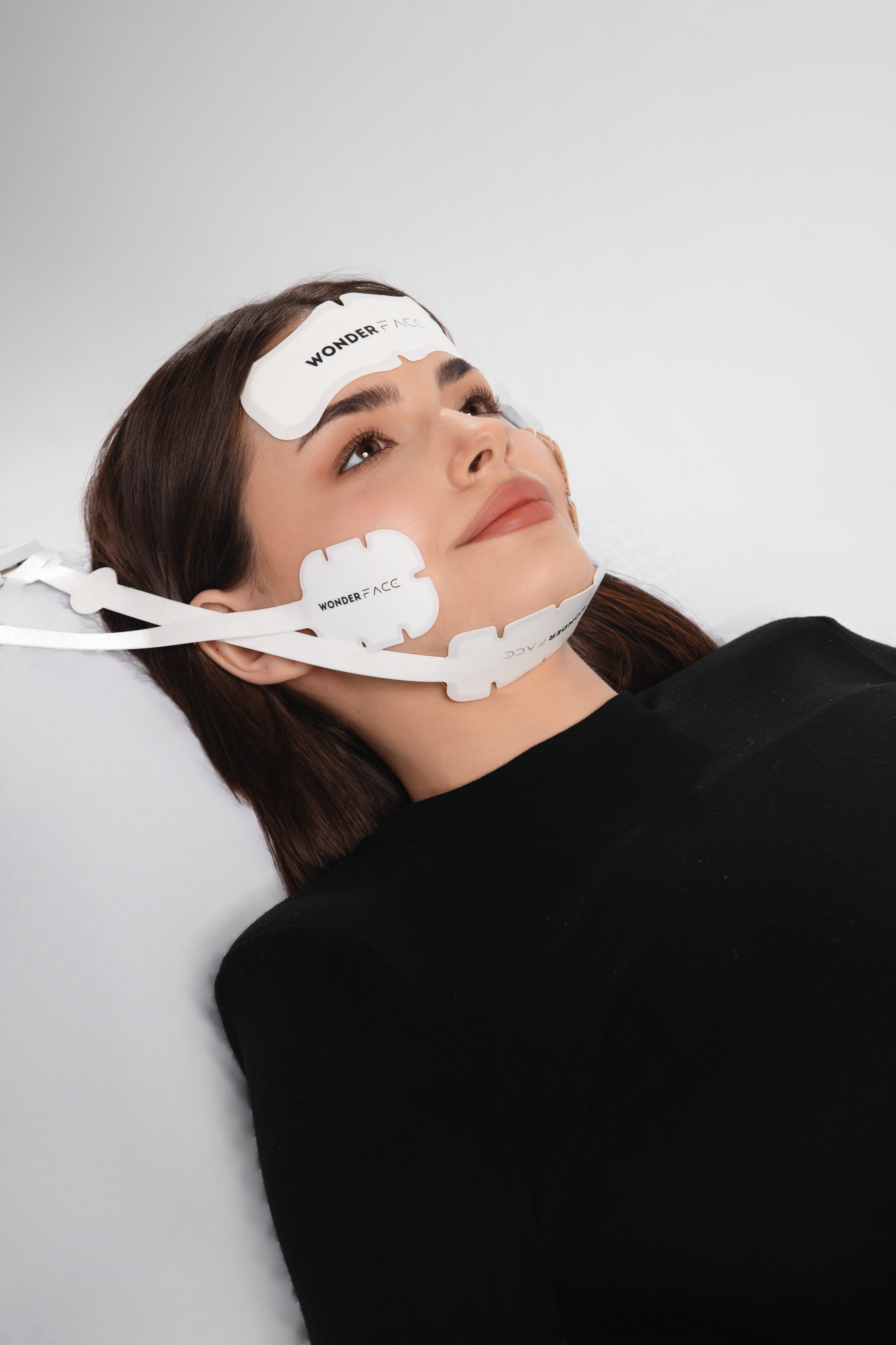 Woman wearing a WonderFace mask with visible branding, it is an ideal value for a laser device purchase.