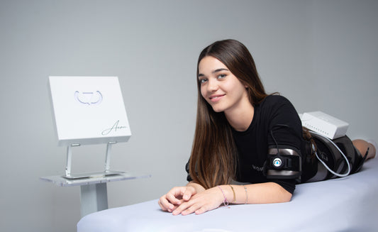 Woman lying on a bed with Wonder Axon medical equipment, including a monitor and arm cuff, in a clinical setting. It is a great value EMF and RF laser purchase.